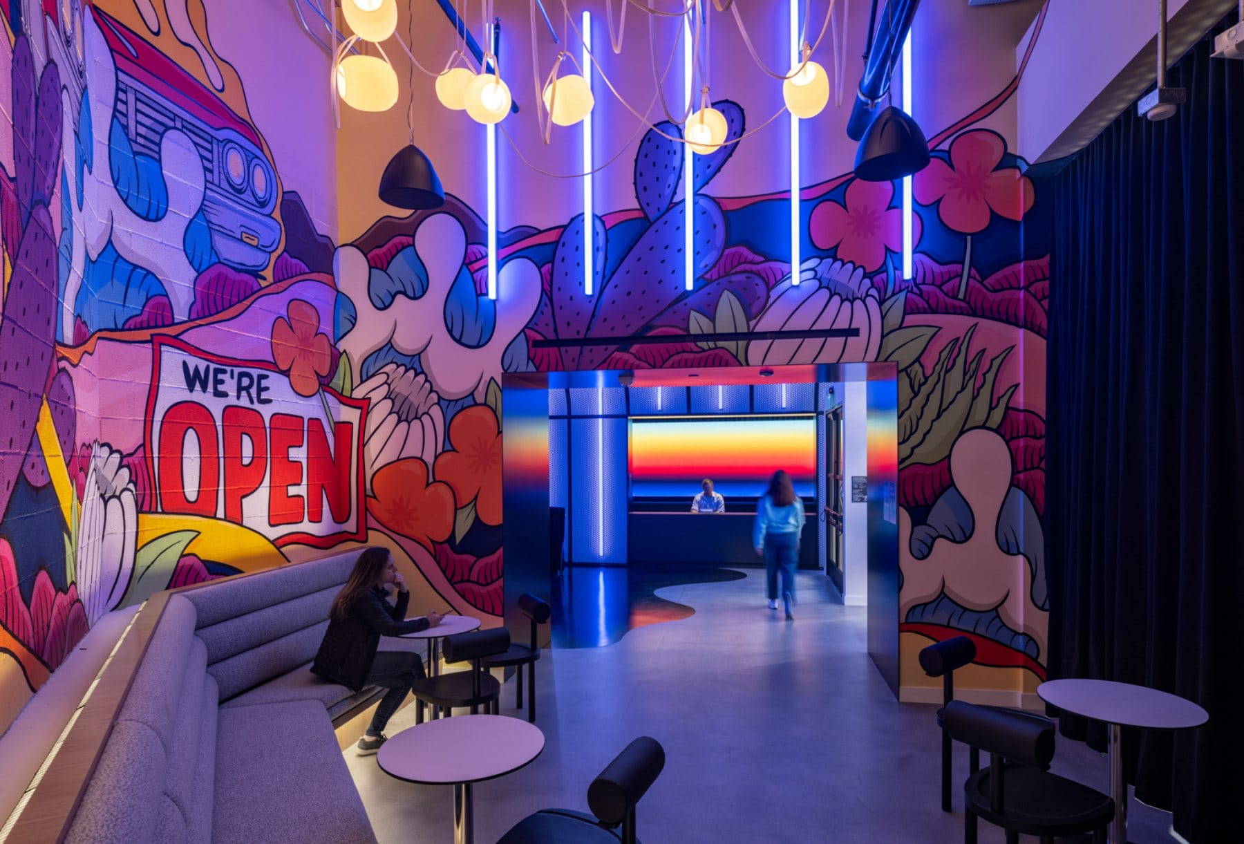 Food hall · communal dining under red ring chandeliers in the timber-framed factory volume