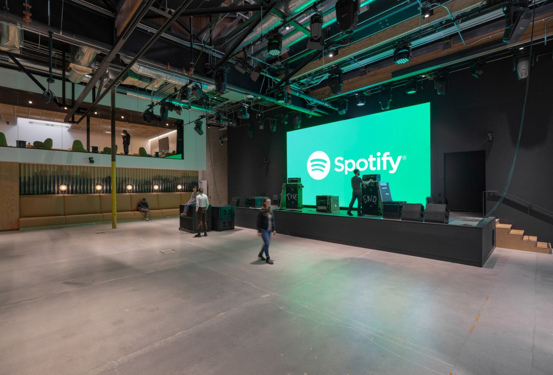 Boardroom · the live-edge slab table beneath the brand screen, with the green-screen volume beyond