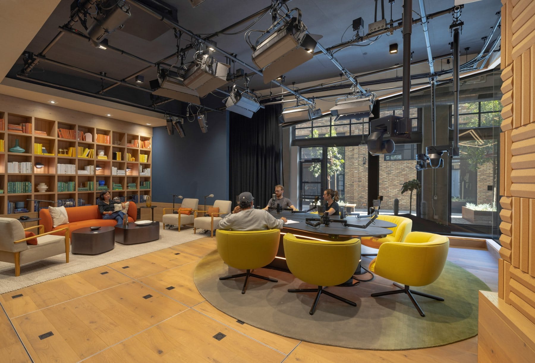 Open podcast studio · the library set with yellow swivels for long-form recording